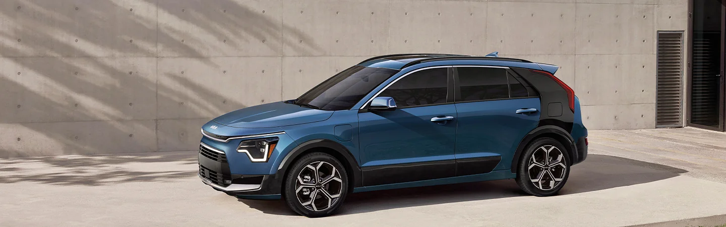 Side view of 2025 Kia Niro EV parked in front of a city building