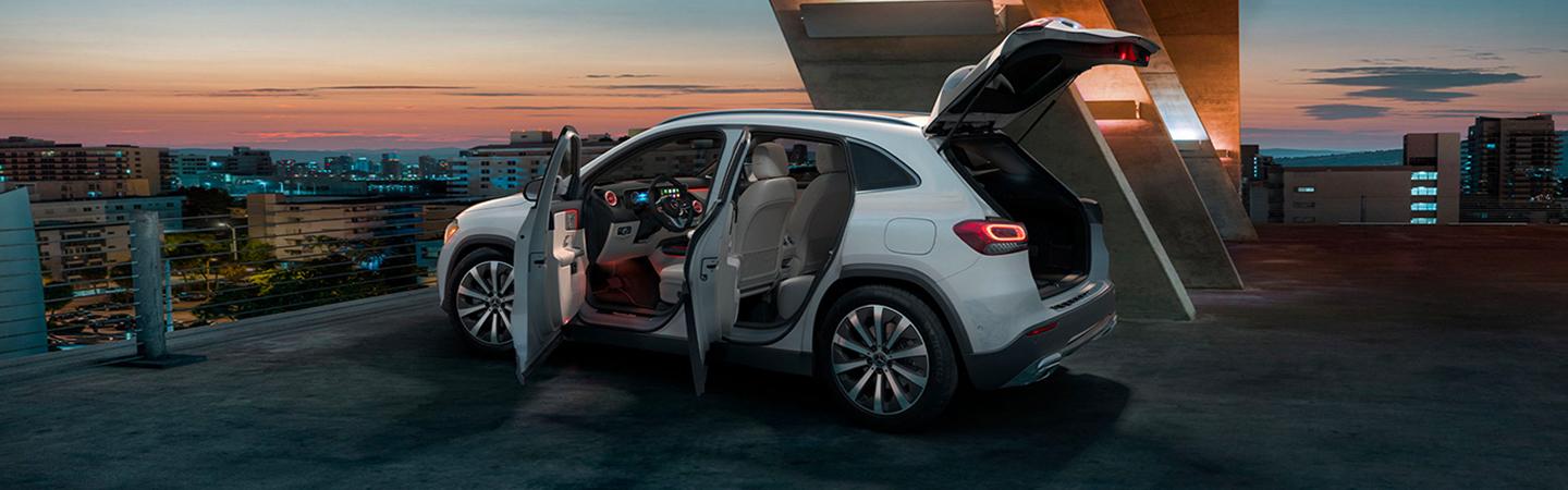 Side view of a white 2021 Mercedes-Benz GLA 250 with the doors and trunk open
