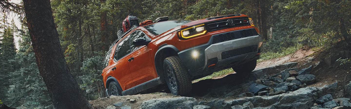 2026 Honda Passport driving on a mountain trail