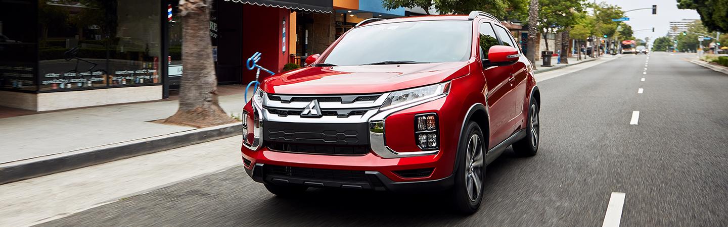Red 2020 Mitsubishi Outlander Sport driving in the city
