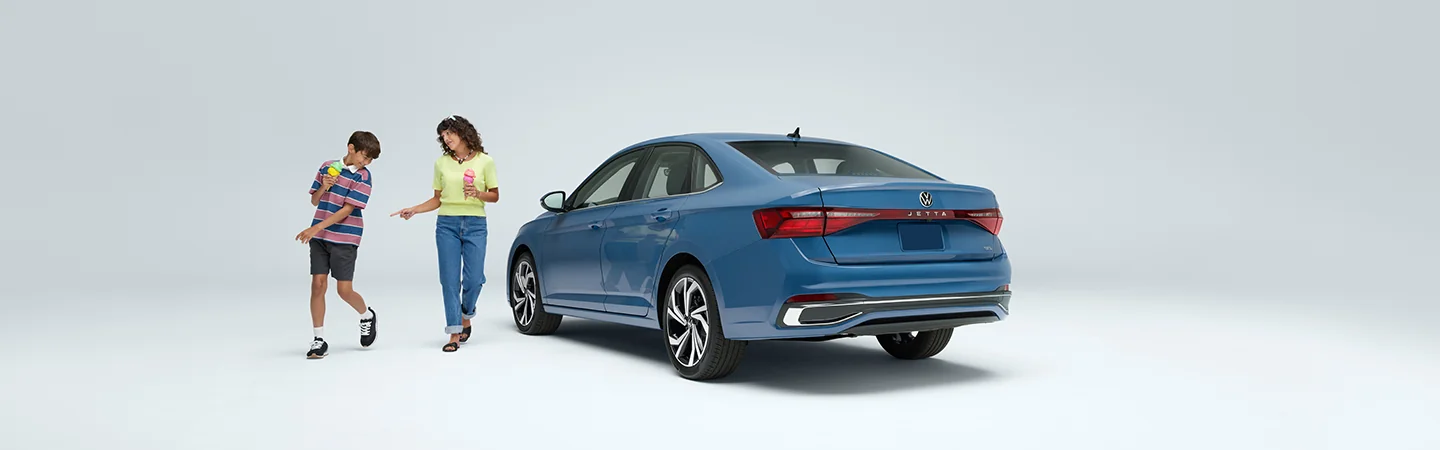 2025 Volkswagen Jetta SEL about to be boarded by two people eating ice cream