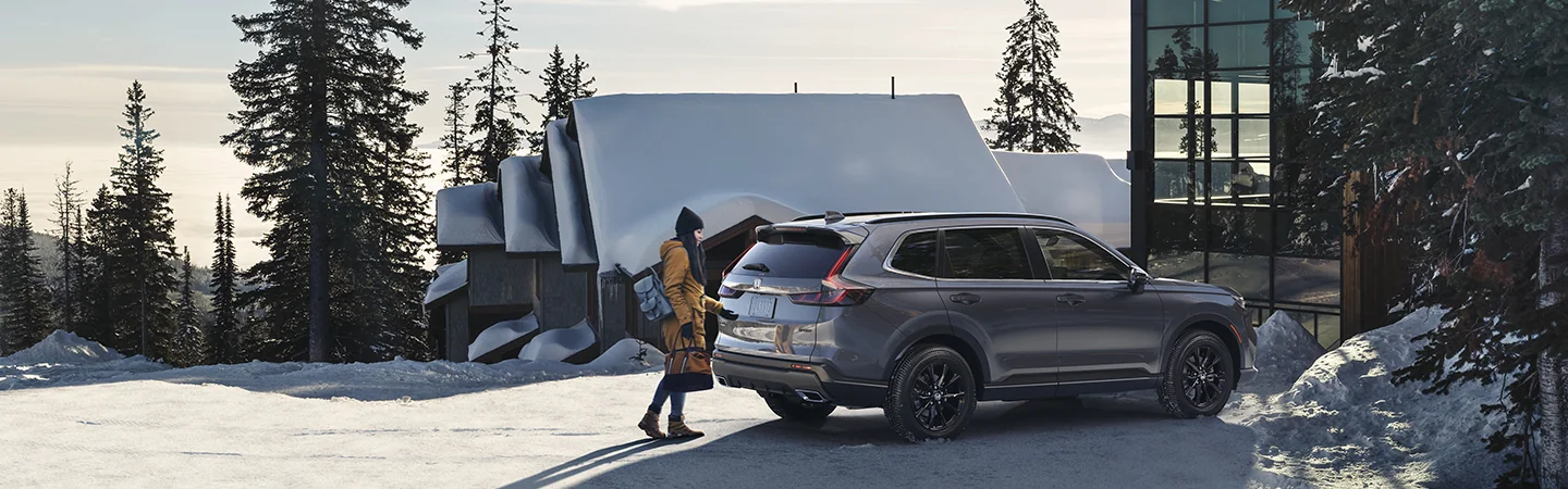 2025 Honda CR-V parked in front of a house in the snow