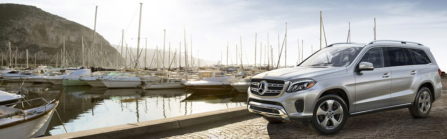 Sliver Mercedes-Benz SUV parked at a marina