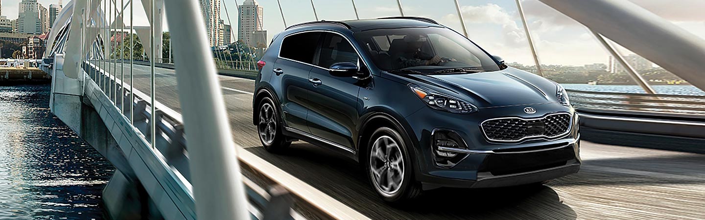 Blue Kia Sportage in motion on a bridge