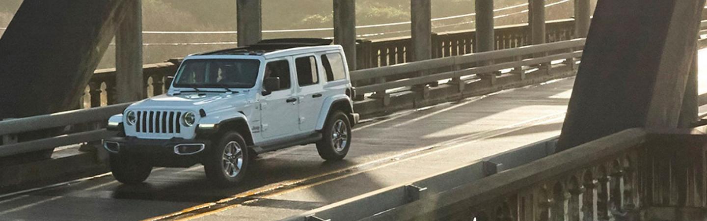 White Wrangler driving on bridge