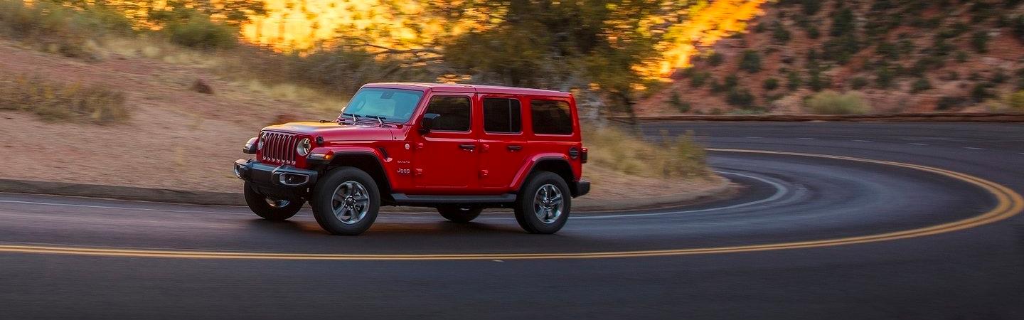 Red Wrangler rounding a bend