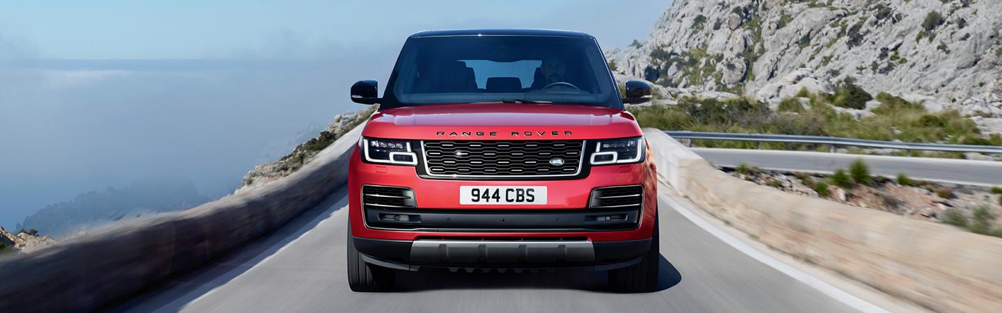 Silver Range Rover rounding a mountain bend