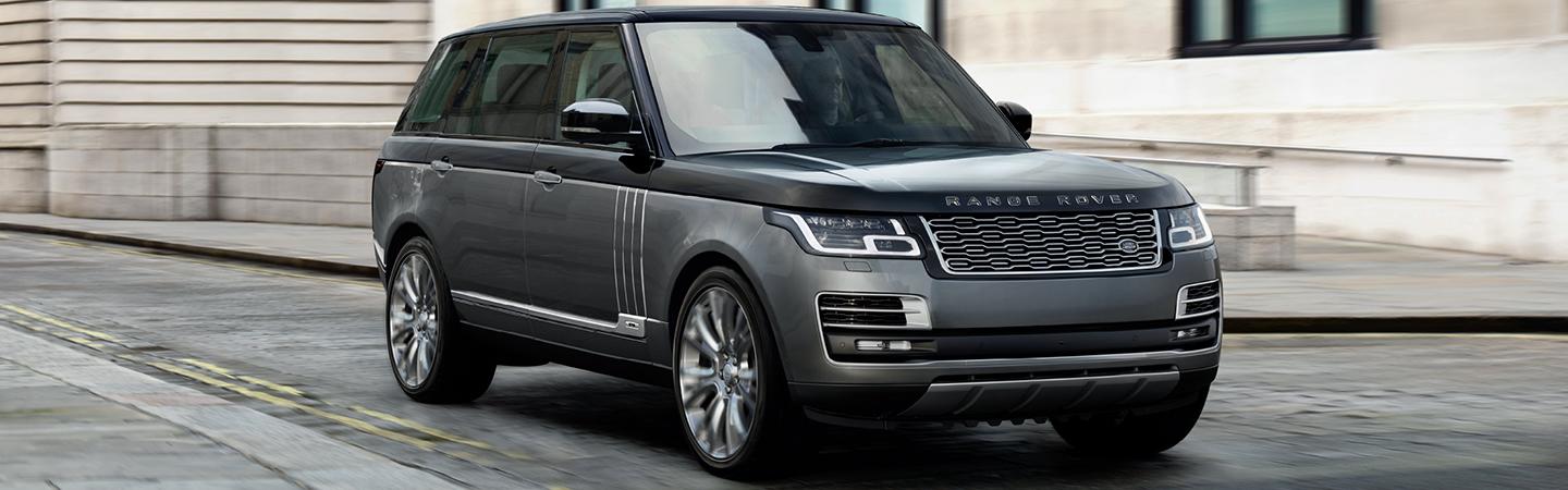 Silver Range Rover driving up a gravel road