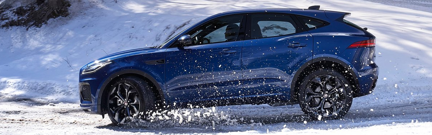 Side profile of the 2021 Jaguar E-PACE driving through snow