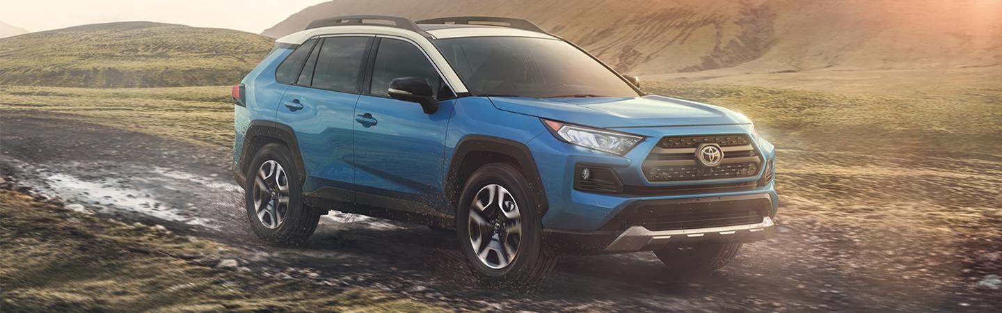 Blue 2020 Toyota RAV4 driving through mud