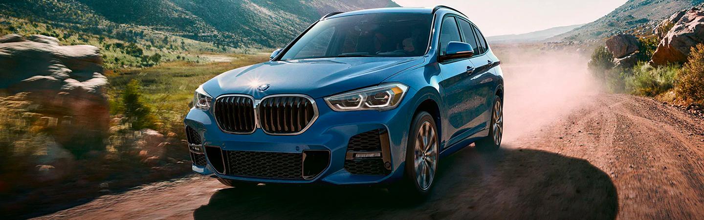 Blue 2021 BMW X1 Driving on Mountain Trail