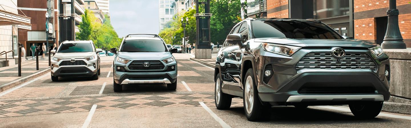 Three Toyota RAV4 models driving in the city