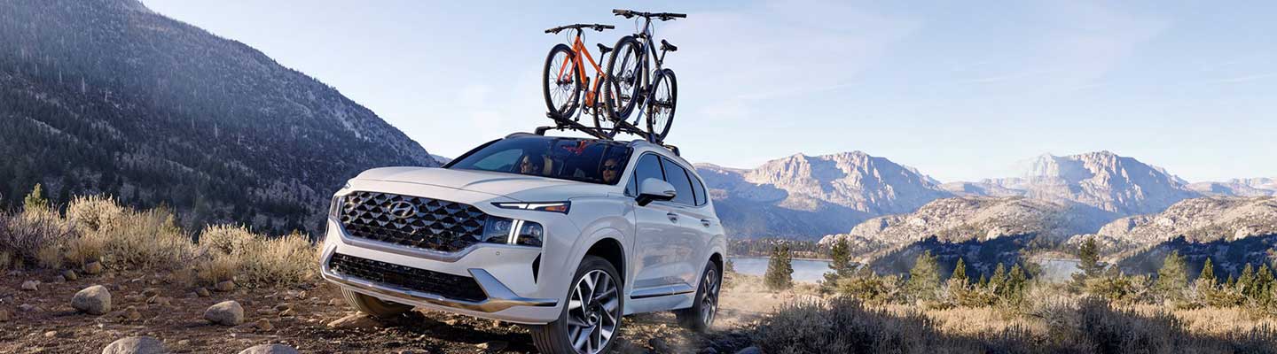 Angled profile of a white Hyundai Santa Fe off-roading