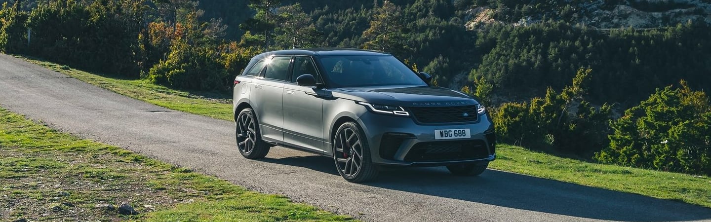 Front passenger side view of silver Velar in motion