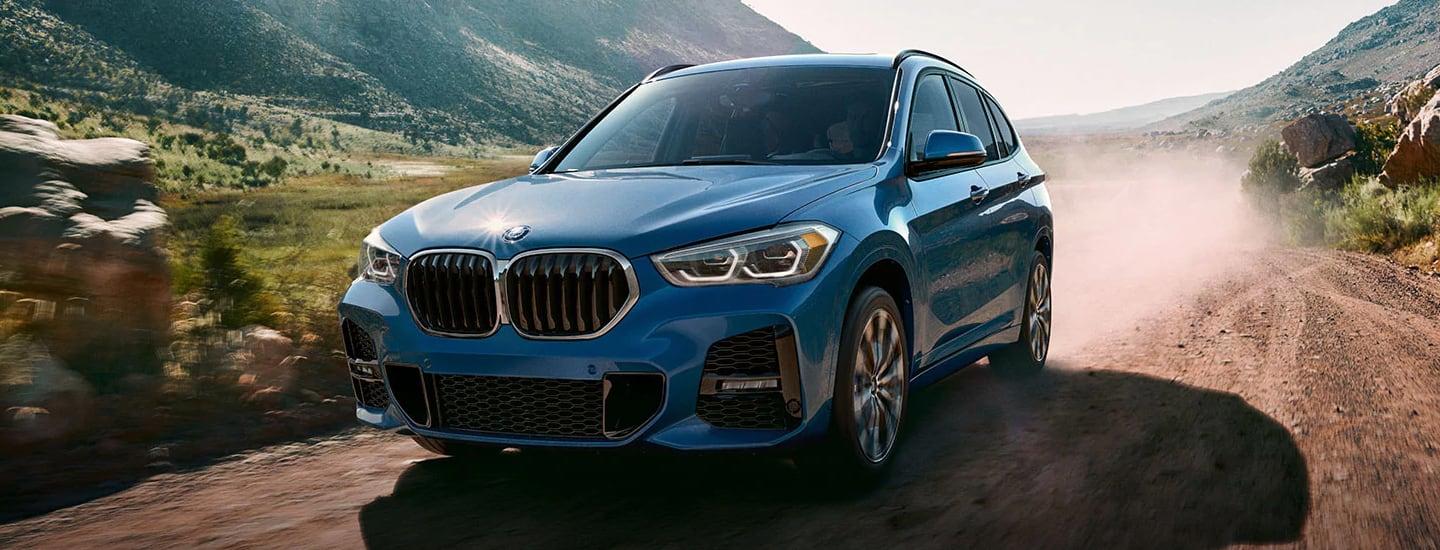 Blue 2021 BMW X1 Driving on Dusty Trail