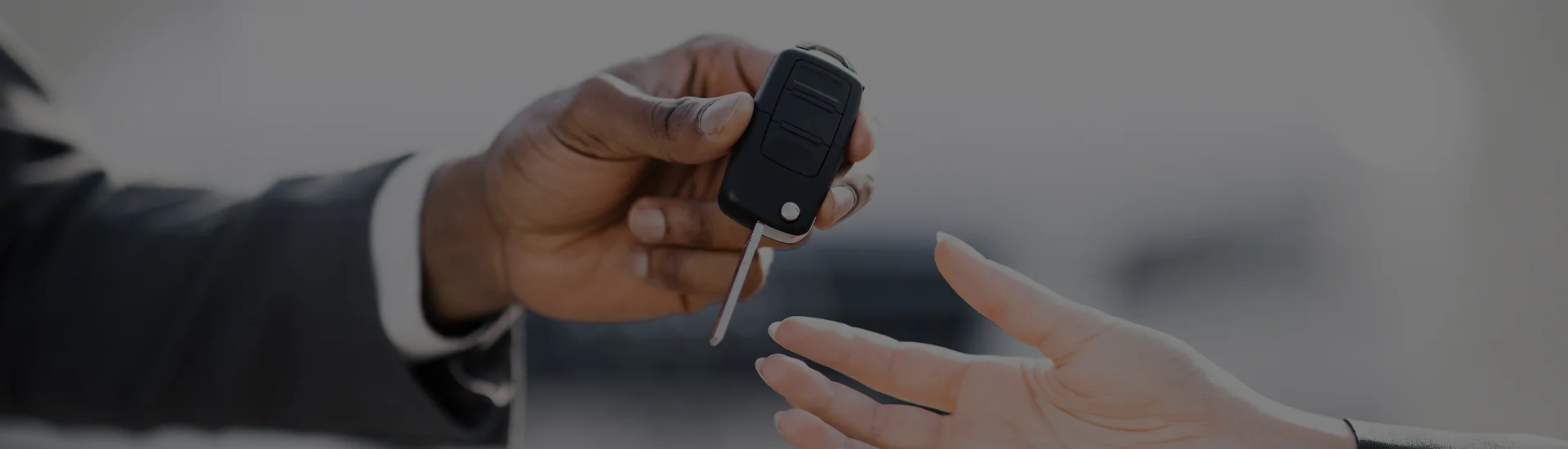 Hands passing a car key