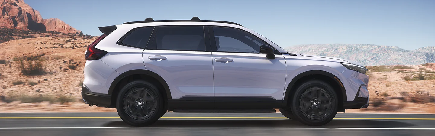 Side view of a Honda CR-V driving on a mountain highway