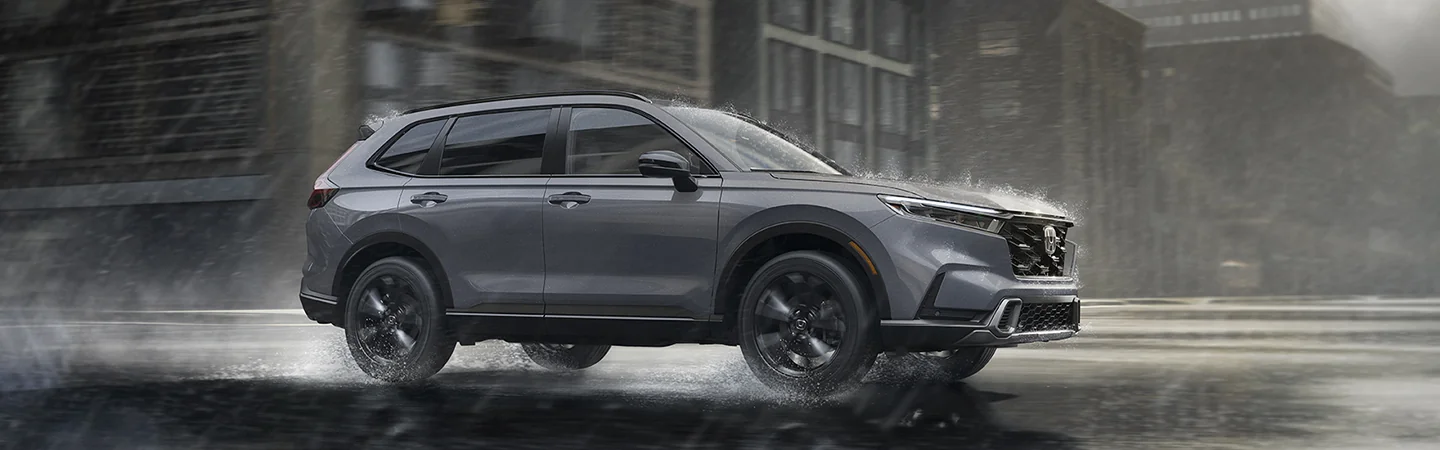 side view of a 2026 Honda CR-V Sport Touring driving in the rain