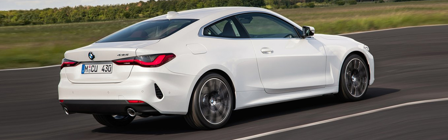 rear view of white 2021 BMW 4 Series Coupe Driving on road