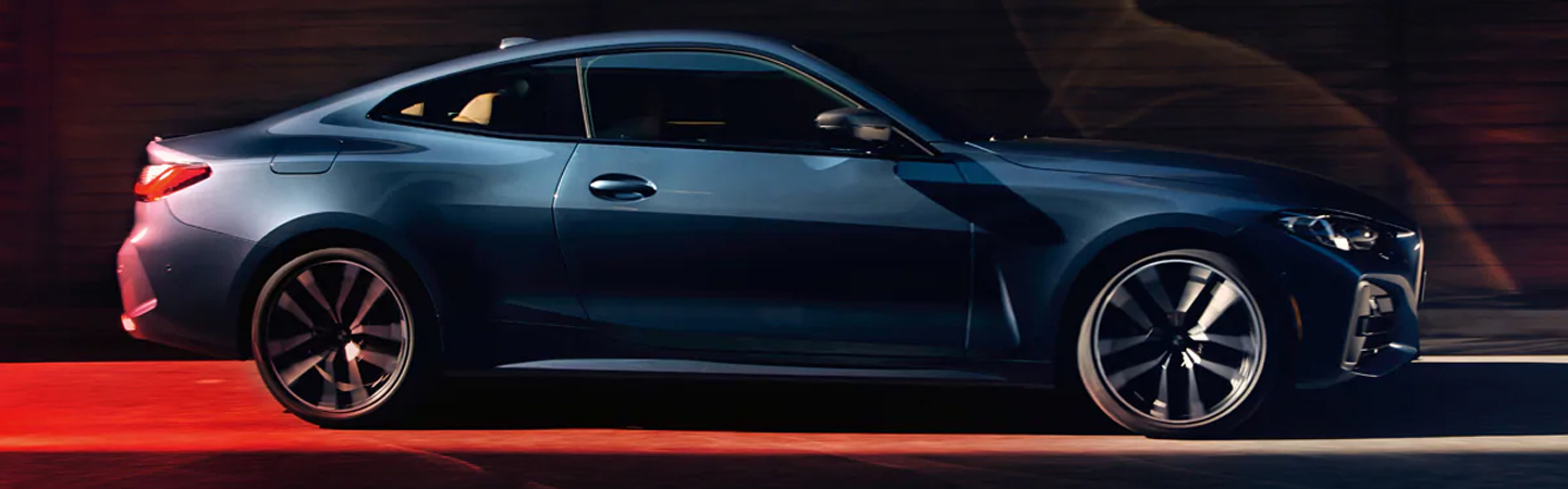Side view of blue 2021 BMW 4 Series Coupe under red light