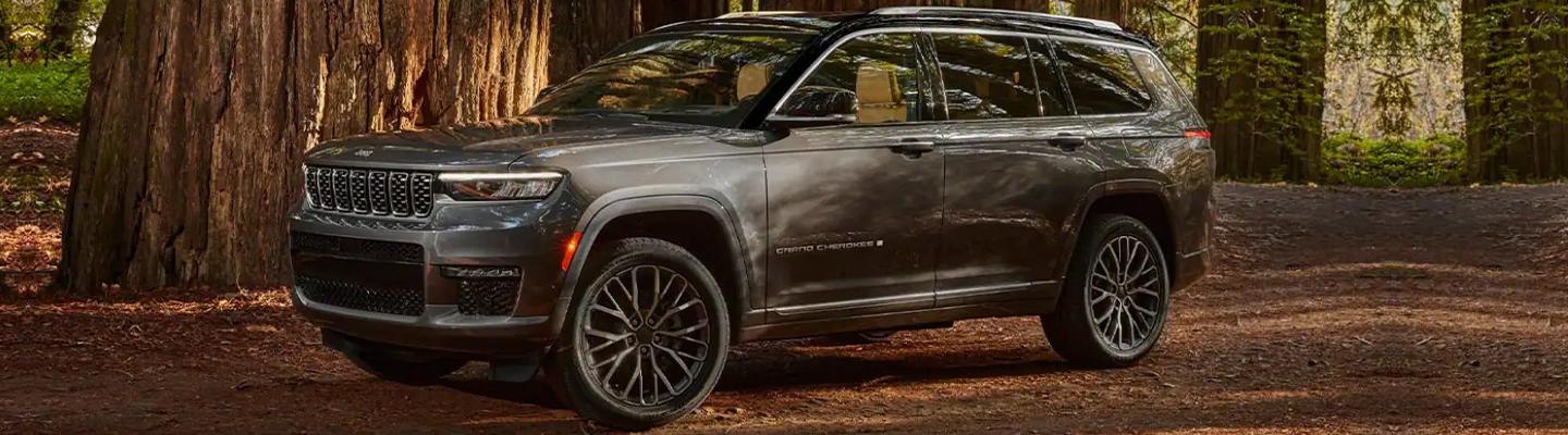 Angled profile of a Jeep Grand Cherokee L driving in a forest