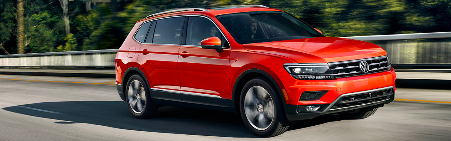 Side profile of a red 2019 Volkswagen Tiguan in motion