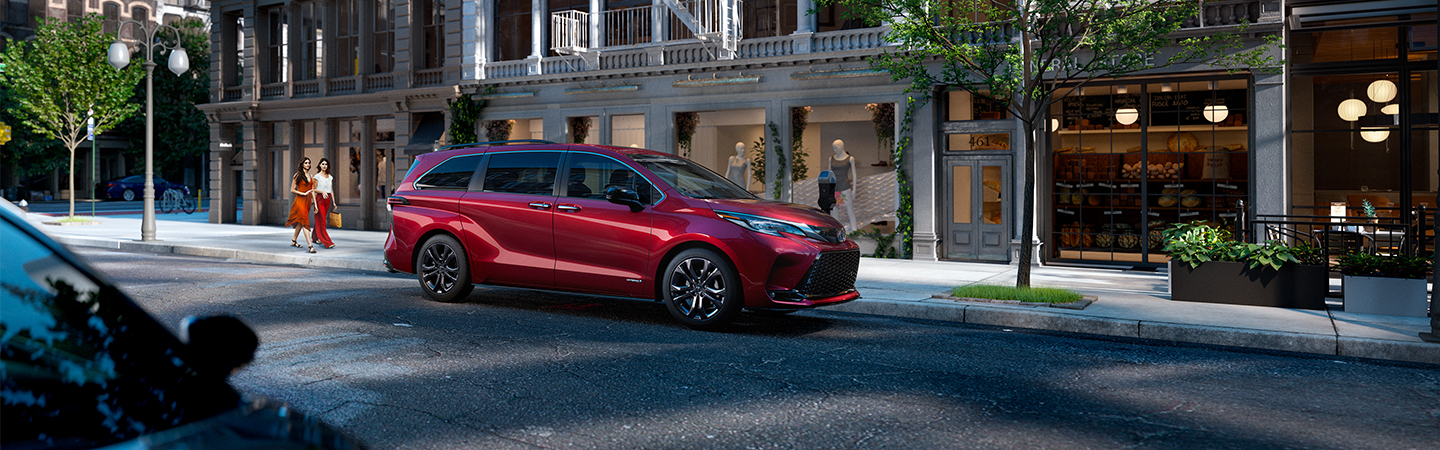 Red 2020 Toyota Sienna parked on city street at night