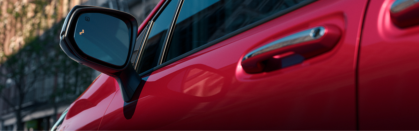 Close up of driver’s side mirror of red 2020 Toyota Sienna 