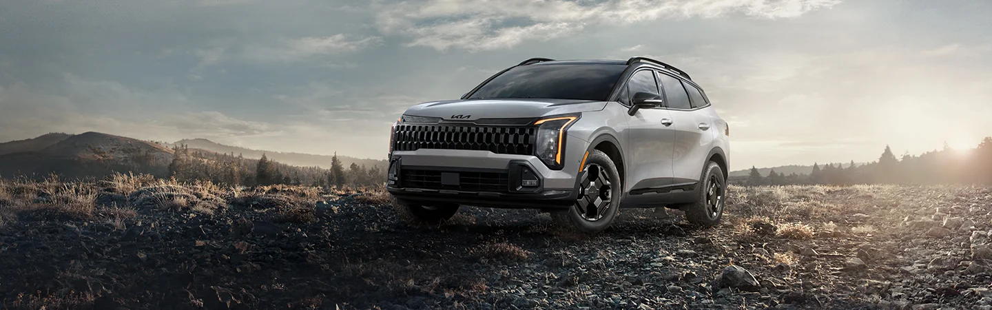 2026 Kia Sportage parked in front of a mountainanous landscape