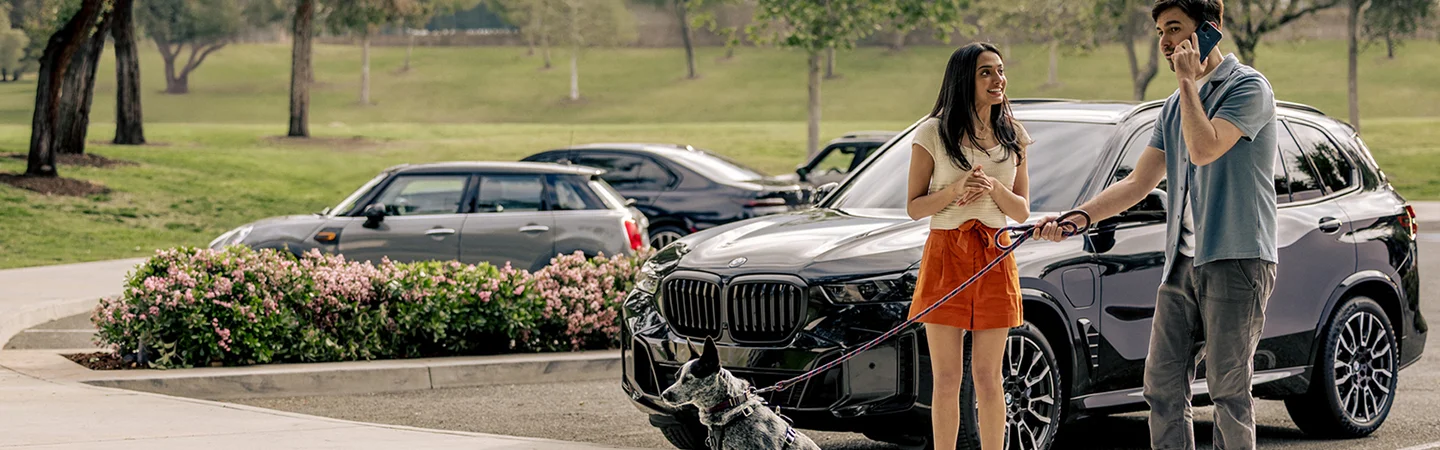 new BMW parked near dog walkers