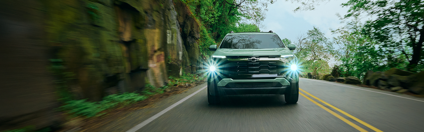 green Chevy Equinox with headlights on