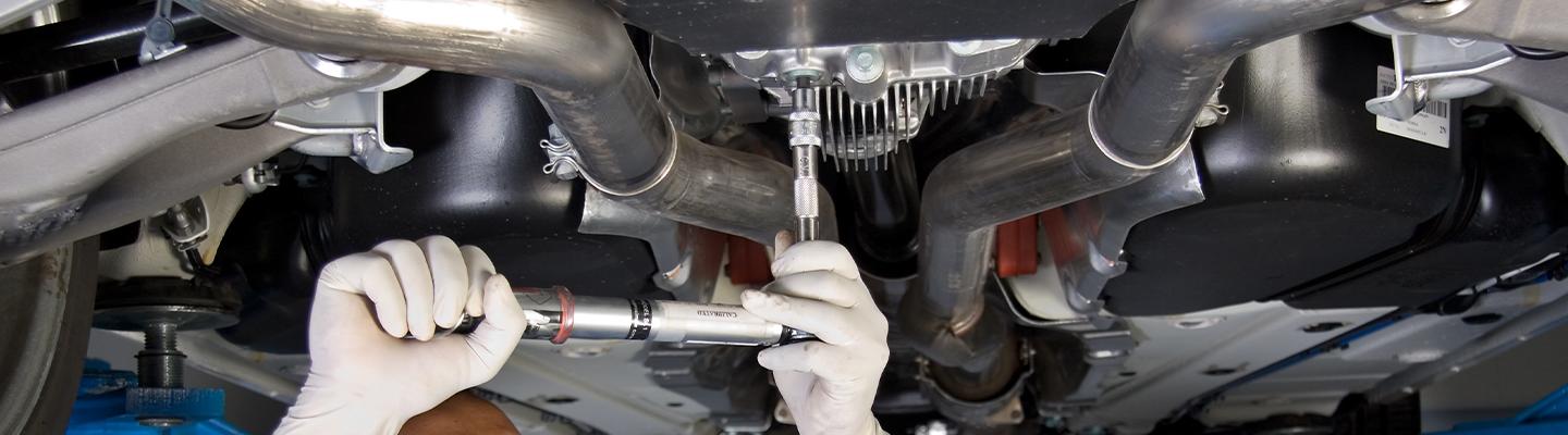 Auto mechaninc working under car on lift
