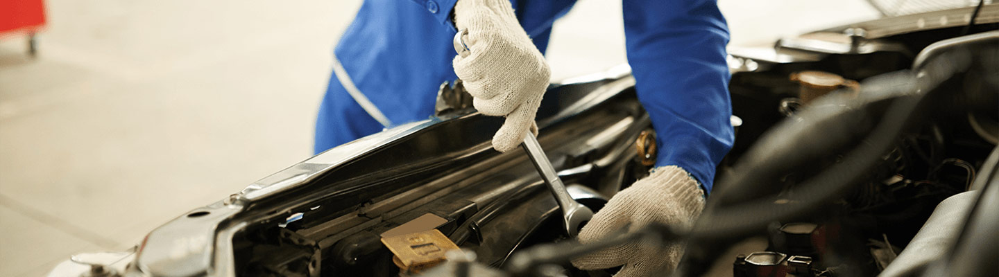 Auto mechanic working on car