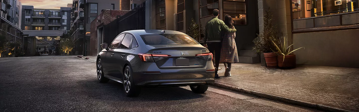 Rear view of the 2026 Honda Civic parked on a city street in front of a residence